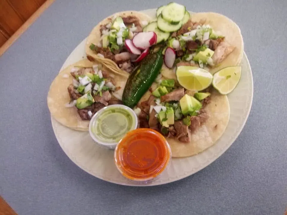 Tacos with radish, cucumber, a grilled jalapeño and two salsas