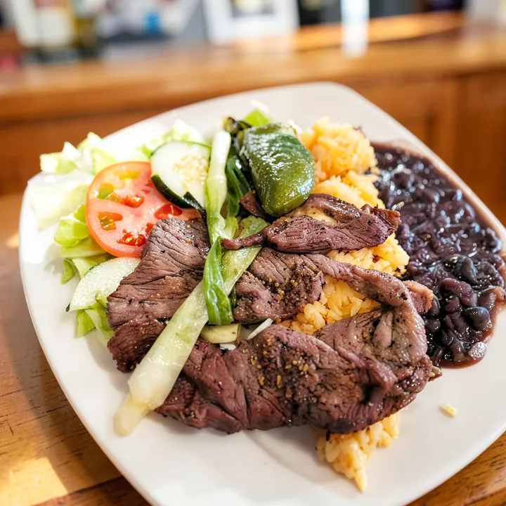 Thin steak with rice, black beans and salad