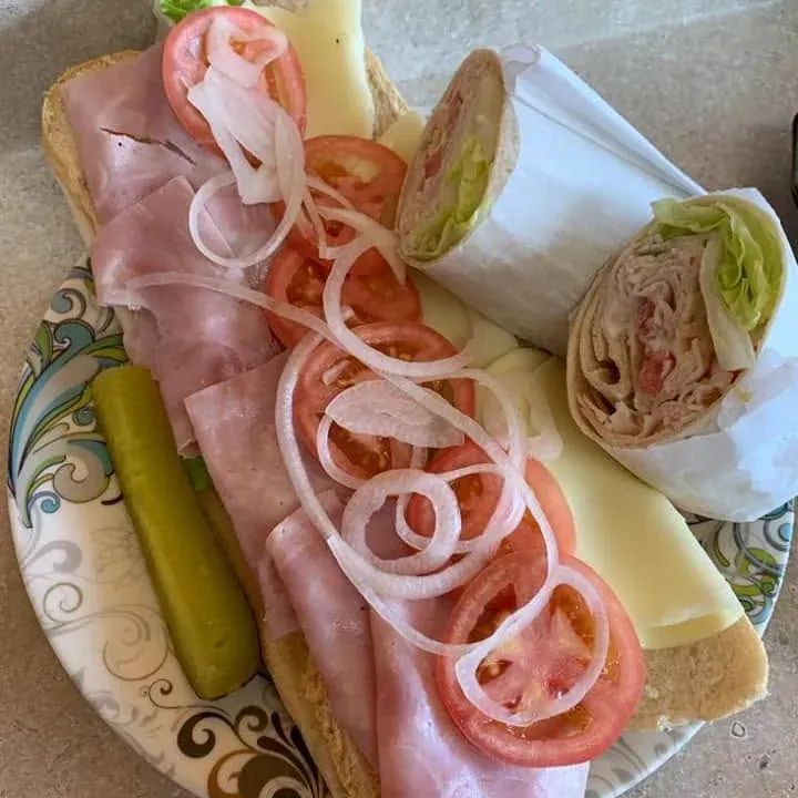 A cold cut platter with onion and tomato, and a wrap