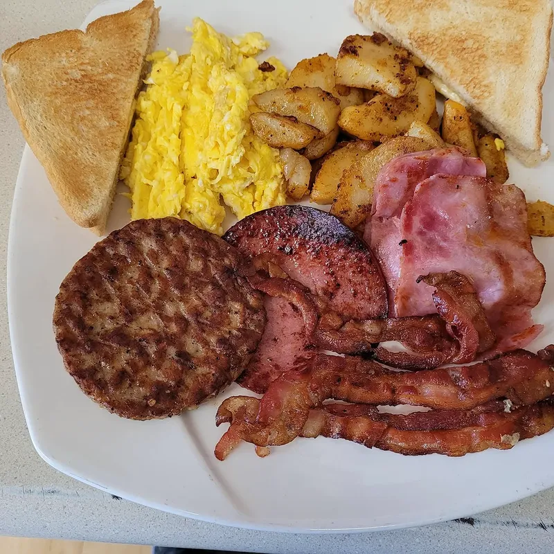 Scrambled eggs, home fries, toast, sausage, pork roll and bacon on a platter